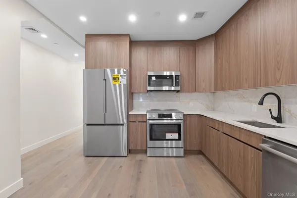 a kitchen with stainless steel appliances granite countertop a refrigerator sink and stove