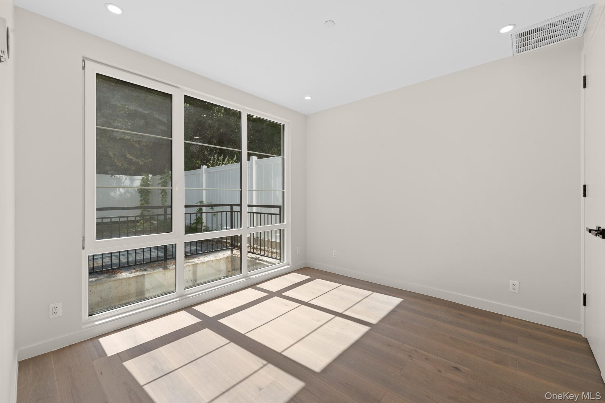 310 Fenimore Street, Unit 1 Brooklyn, NY 11225 - Photo 10 of 15 an empty room with wooden floor and windows