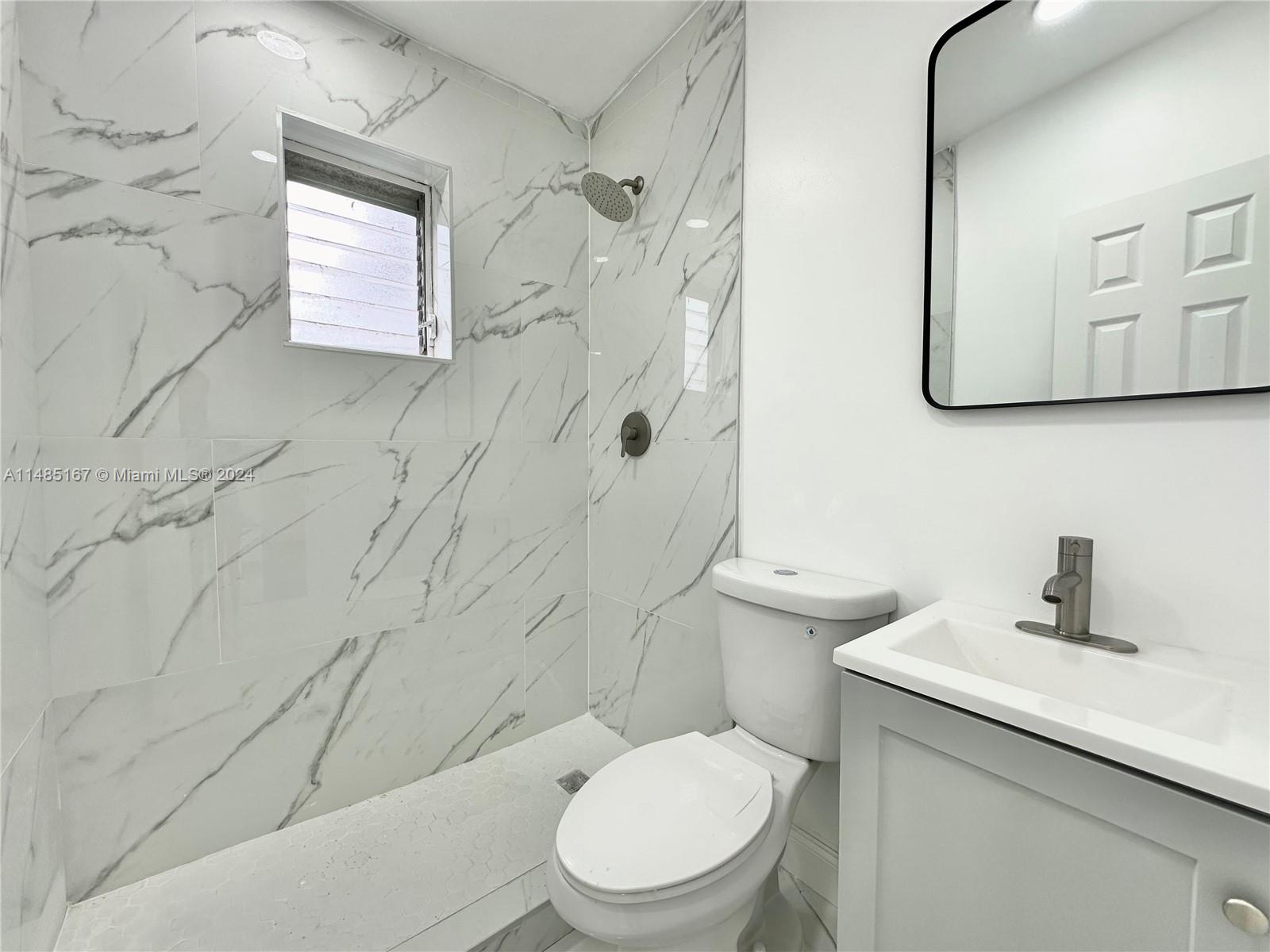 11470 Southwest 215th Street Miami, FL 33189 - Photo 11 of 18 a bathroom with a toilet sink shower and mirror