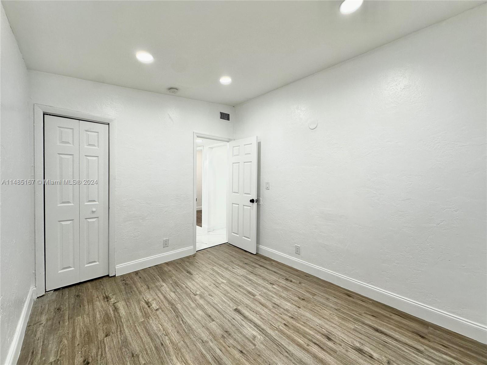 11470 Southwest 215th Street Miami, FL 33189 - Photo 12 of 18 a view of an empty room with wooden floor