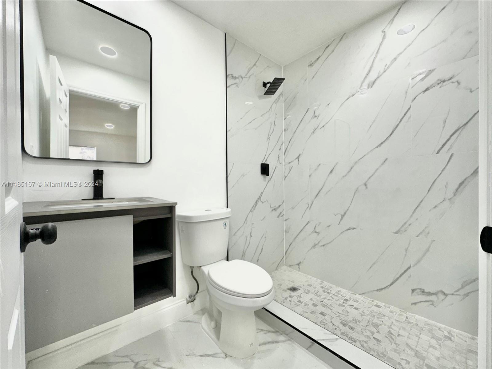 11470 Southwest 215th Street Miami, FL 33189 - Photo 14 of 18 a bathroom with a toilet sink and mirror