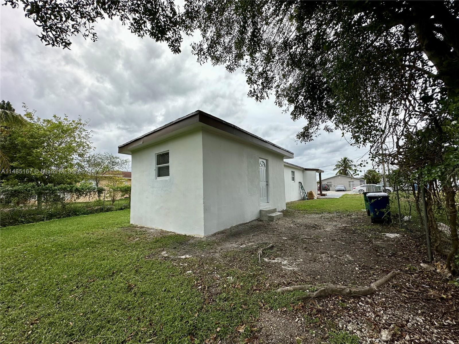 11470 Southwest 215th Street Miami, FL 33189 - Photo 17 of 18 a view of a house with a yard