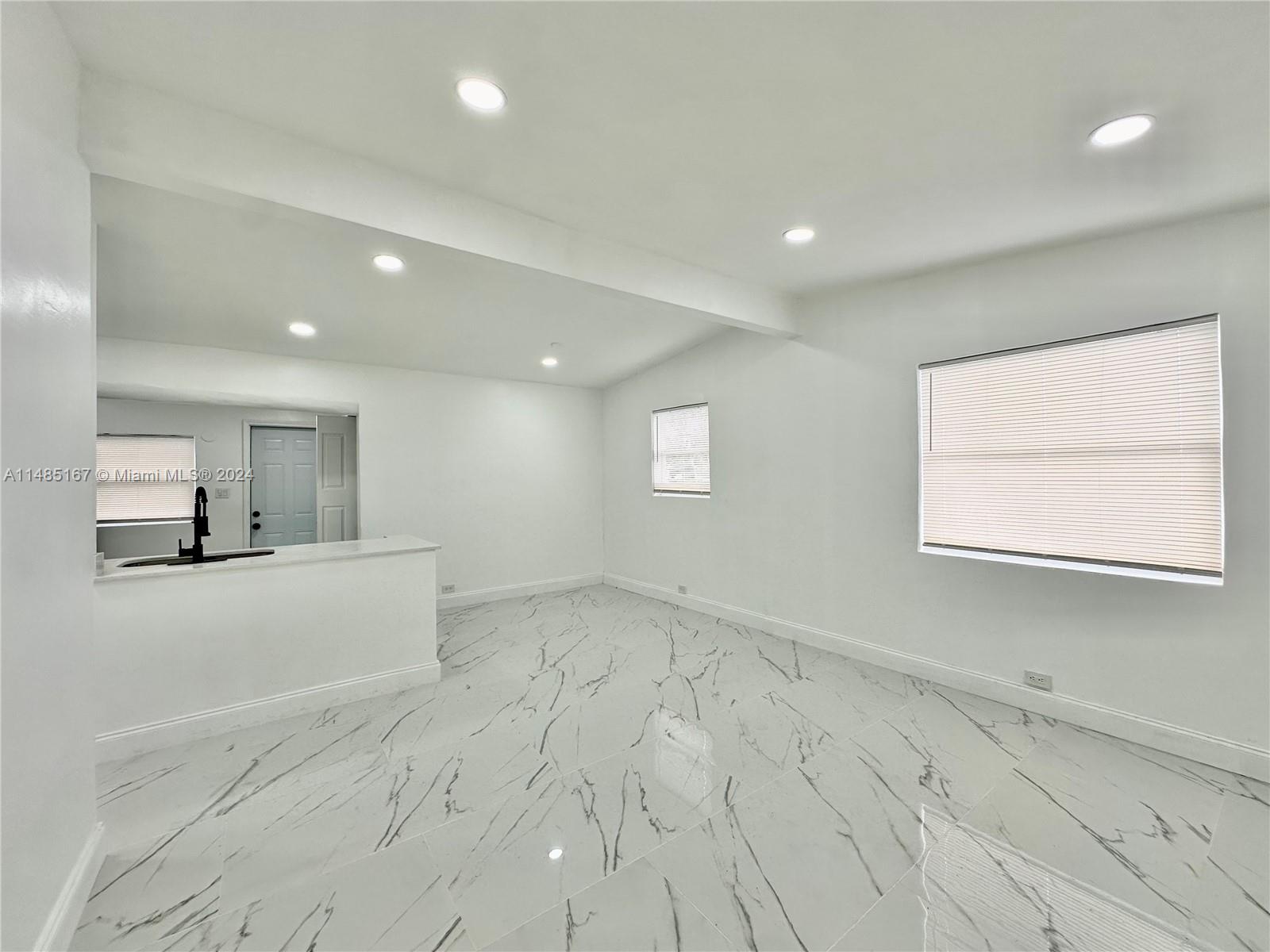 11470 Southwest 215th Street Miami, FL 33189 - Photo 4 of 18 wooden floor in an empty room with a window