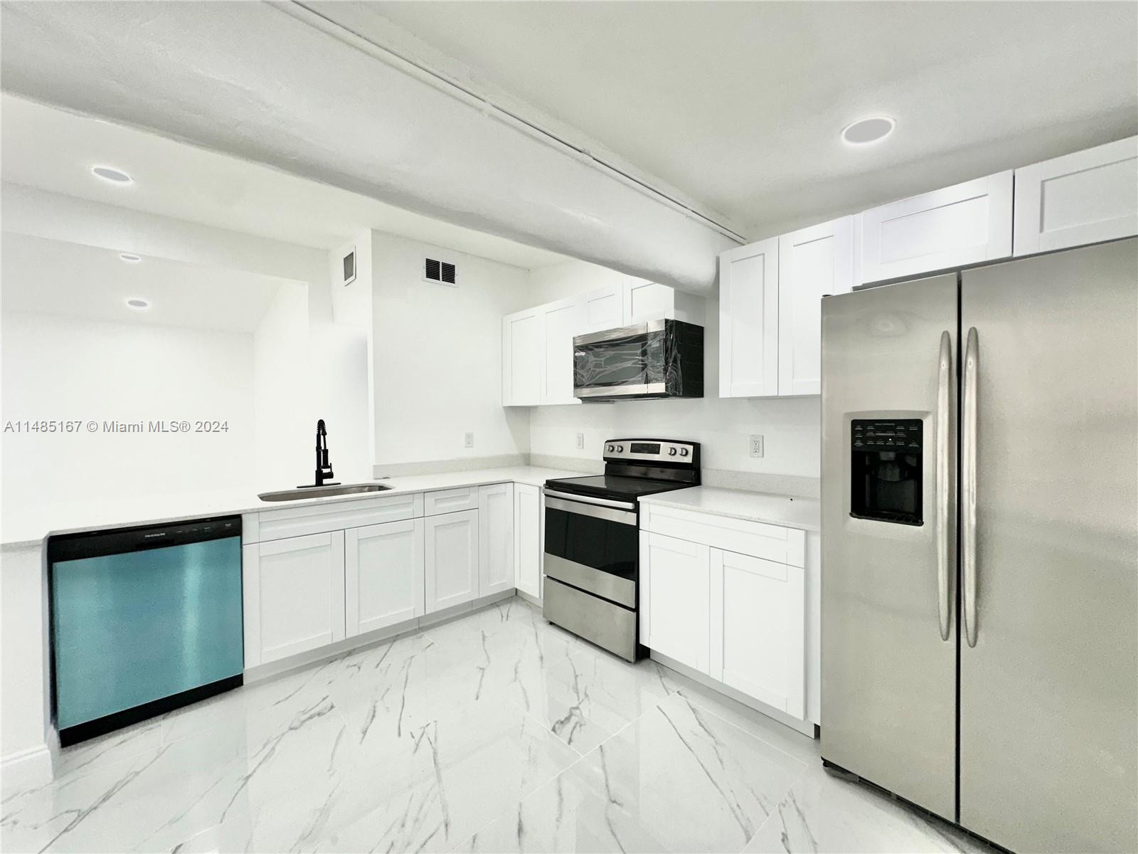 11470 Southwest 215th Street Miami, FL 33189 - Photo 6 of 18 a kitchen with a refrigerator stove and sink