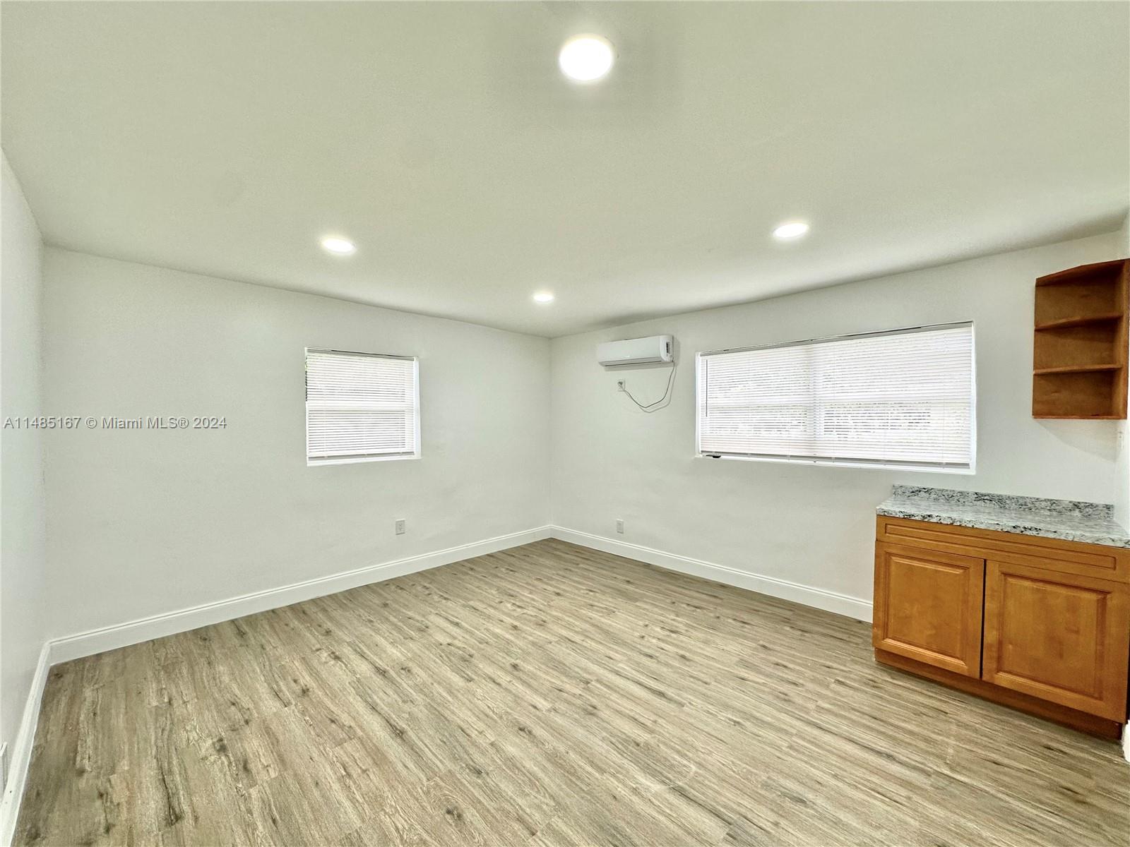 11470 Southwest 215th Street Miami, FL 33189 - Photo 9 of 18 an empty room with wooden floor and windows