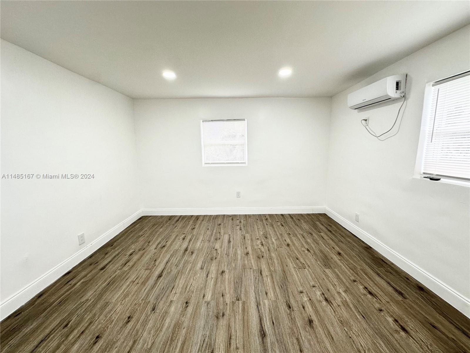 11470 Southwest 215th Street Miami, FL 33189 - Photo 10 of 18 a view of a room with wooden floor and white walls