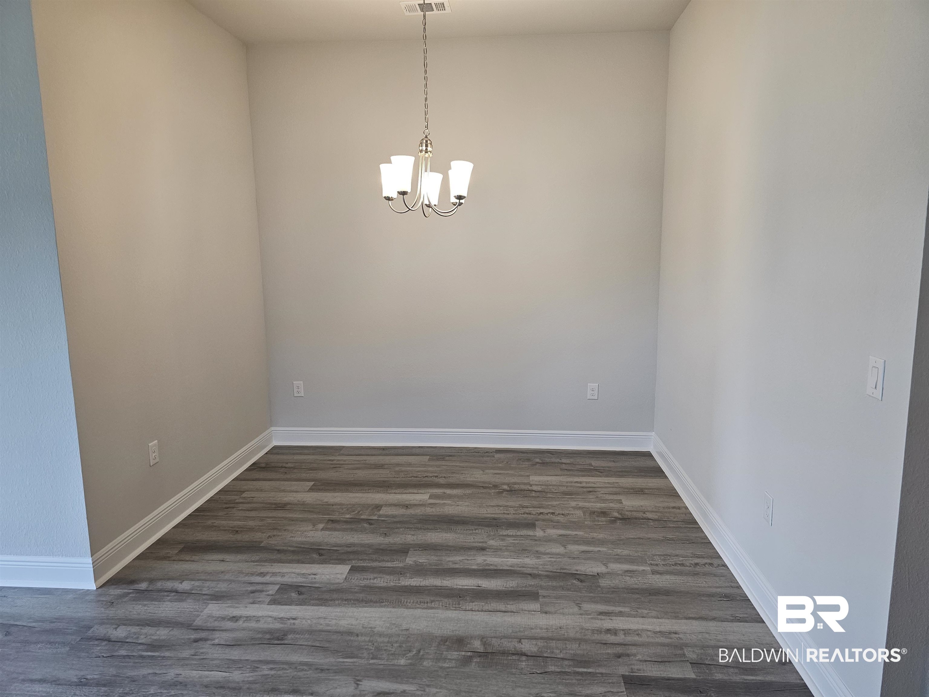 1412 Plymouth Drive Foley, AL 36535 - Photo 3 of 10 Unfurnished dining area with hardwood / wood-style floors and an inviting chandelier