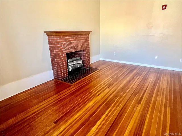 a room with wooden floor a fireplace and wooden floor