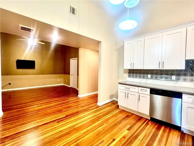 a view of a kitchen with kitchen island a sink stainless steel appliances and cabinets