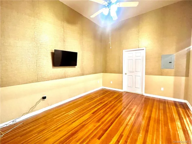 a view of a room with wooden floor and a ceiling fan