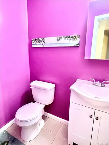 a bathroom with a toilet a sink and wooden floor