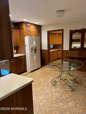 a living room with table chairs and a refrigerator