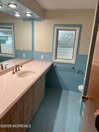 a bathroom with a double vanity sink a mirror and a bathtub
