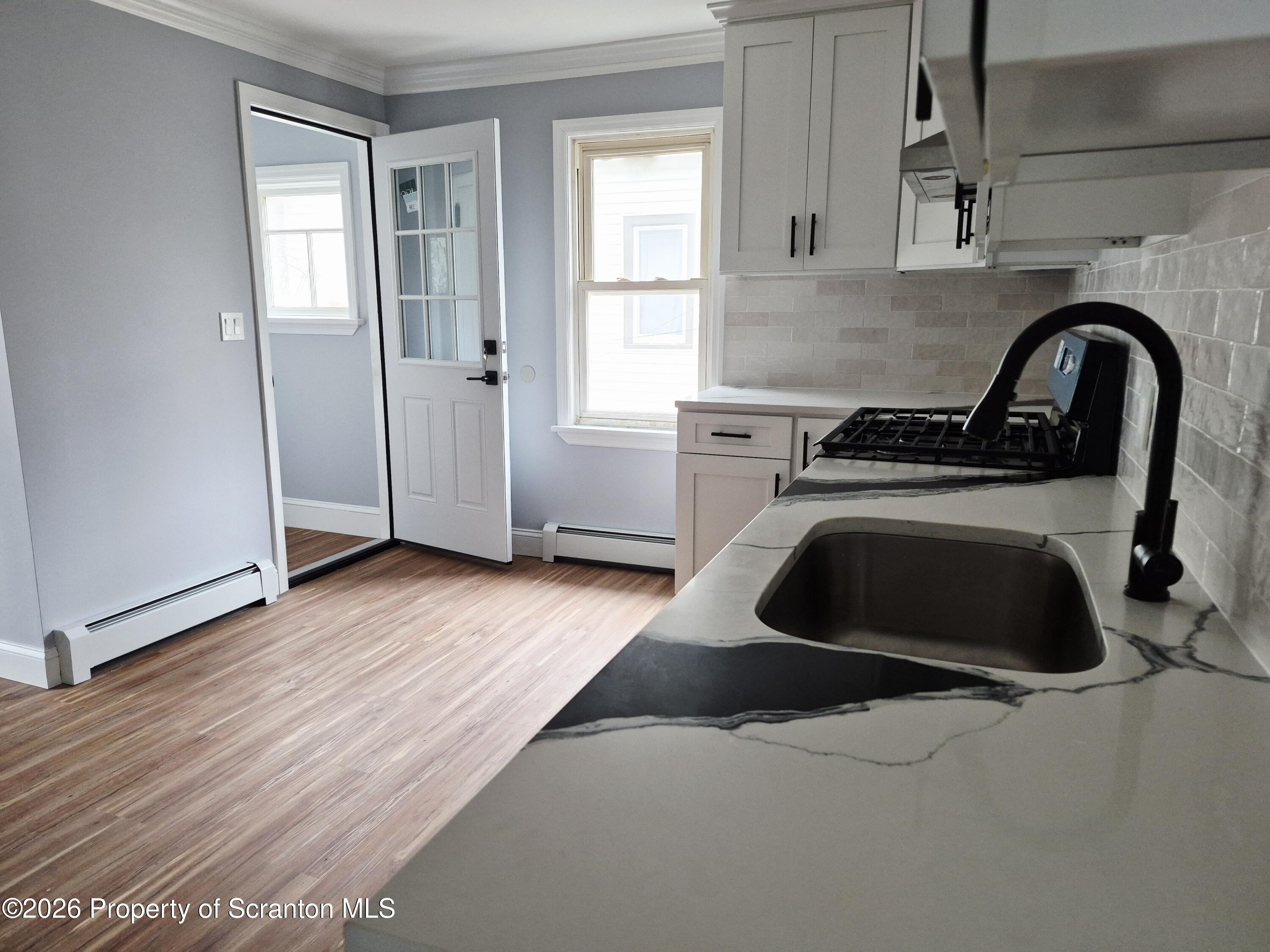 1132 Lloyd Street Scranton, PA 18508 - Photo 22 of 37 a kitchen with granite countertop a stove a sink and a window