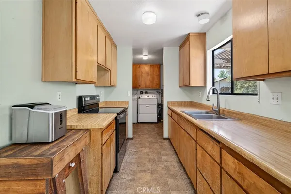 a kitchen with granite countertop a sink a counter top space stainless steel appliances and cabinets