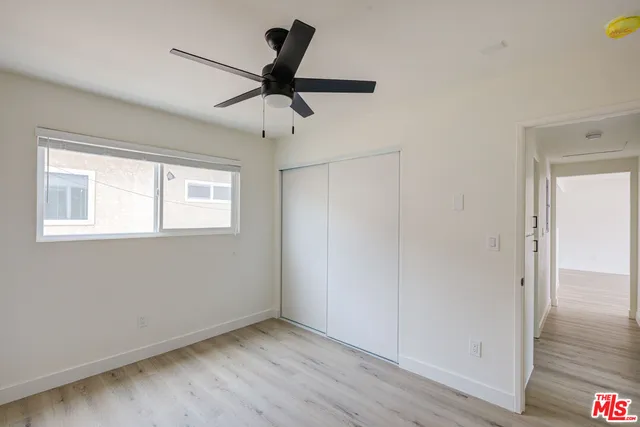 a view of a big room with wooden floor closet and windows