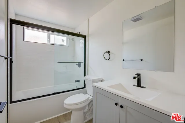 a bathroom with a sink a toilet a window and vanity