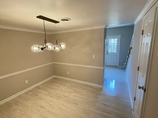 a view of a room with wooden floor and ceiling fan