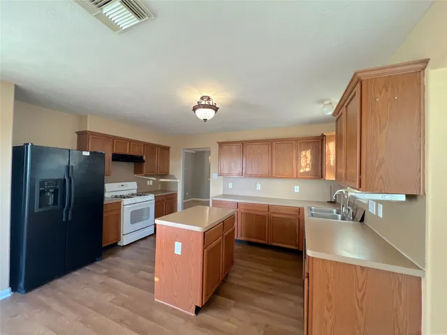 a kitchen with a sink refrigerator and cabinets