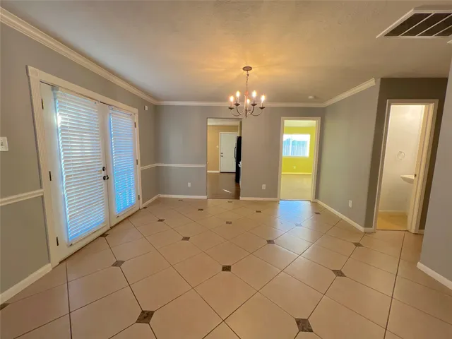 a view of a hallway with wooden floor and chandelier