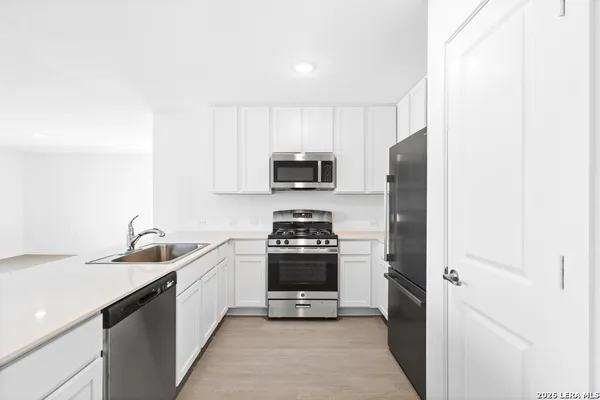 a kitchen with sink a stove and refrigerator
