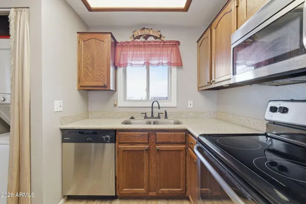 a kitchen with stainless steel appliances a sink dishwasher stove and cabinets