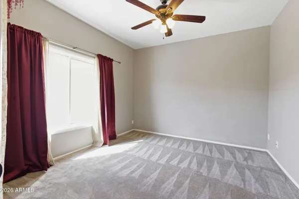 an empty room with closet and a chandelier fan