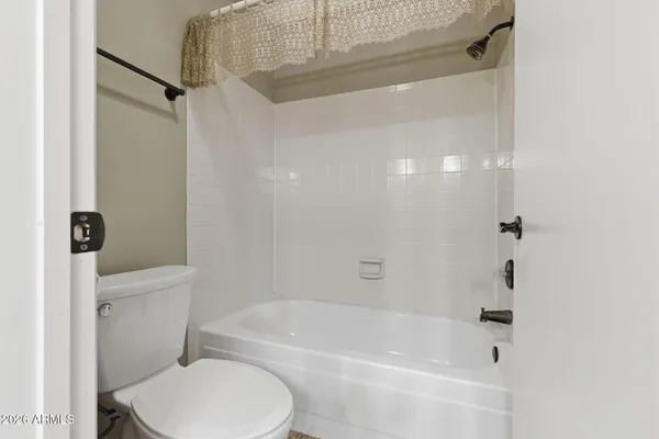 a white toilet sitting next to a bath tub