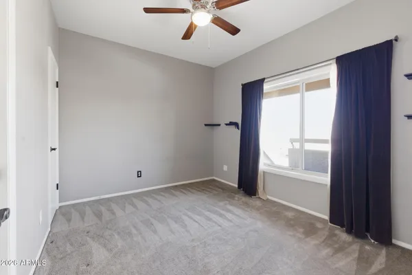 an empty room with fan and windows