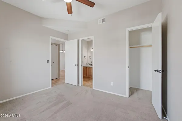 an empty room with closet and windows