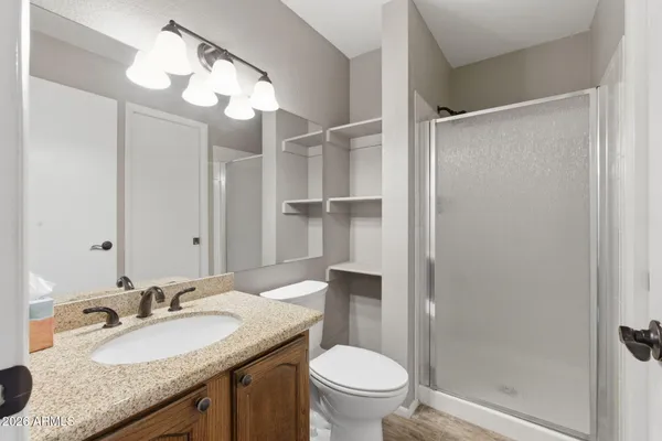a bathroom with a granite countertop sink toilet and shower