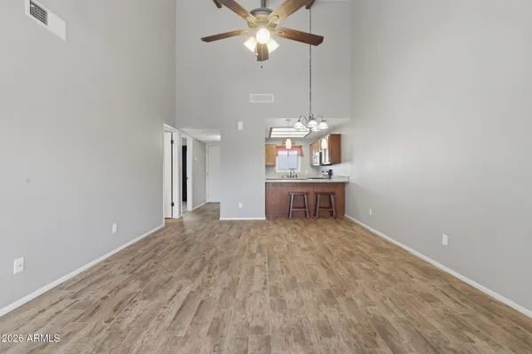 a view of a room with a kitchen and a chandelier fan