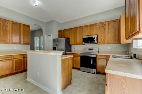 a kitchen with sink a microwave and refrigerator