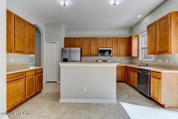 a kitchen with stainless steel appliances granite countertop a stove a sink dishwasher and a refrigerator