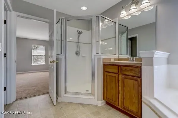 a bathroom with a shower sink and mirror