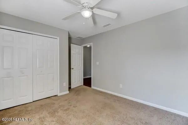 an empty room with a ceiling fan and a window
