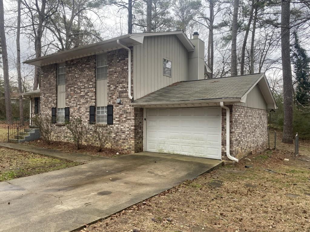 2340 Big Pine Court Conley, GA 30288 - Photo 4 of 25 a front view of a house with a yard and garage