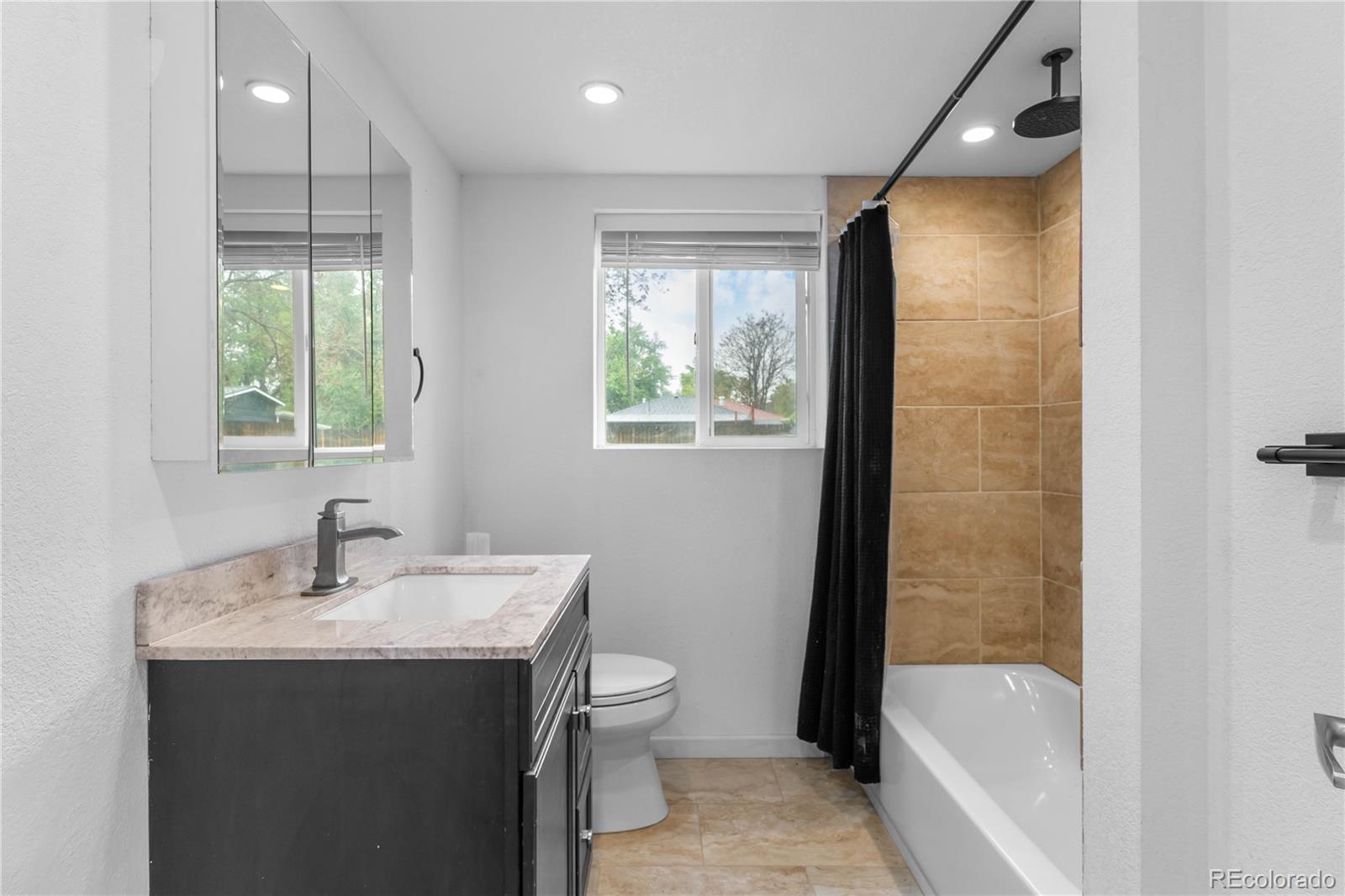 7010 West 44th Avenue Wheat Ridge, CO 80033 - Photo 26 of 31 a bathroom with a sink mirror toilet and bathtub