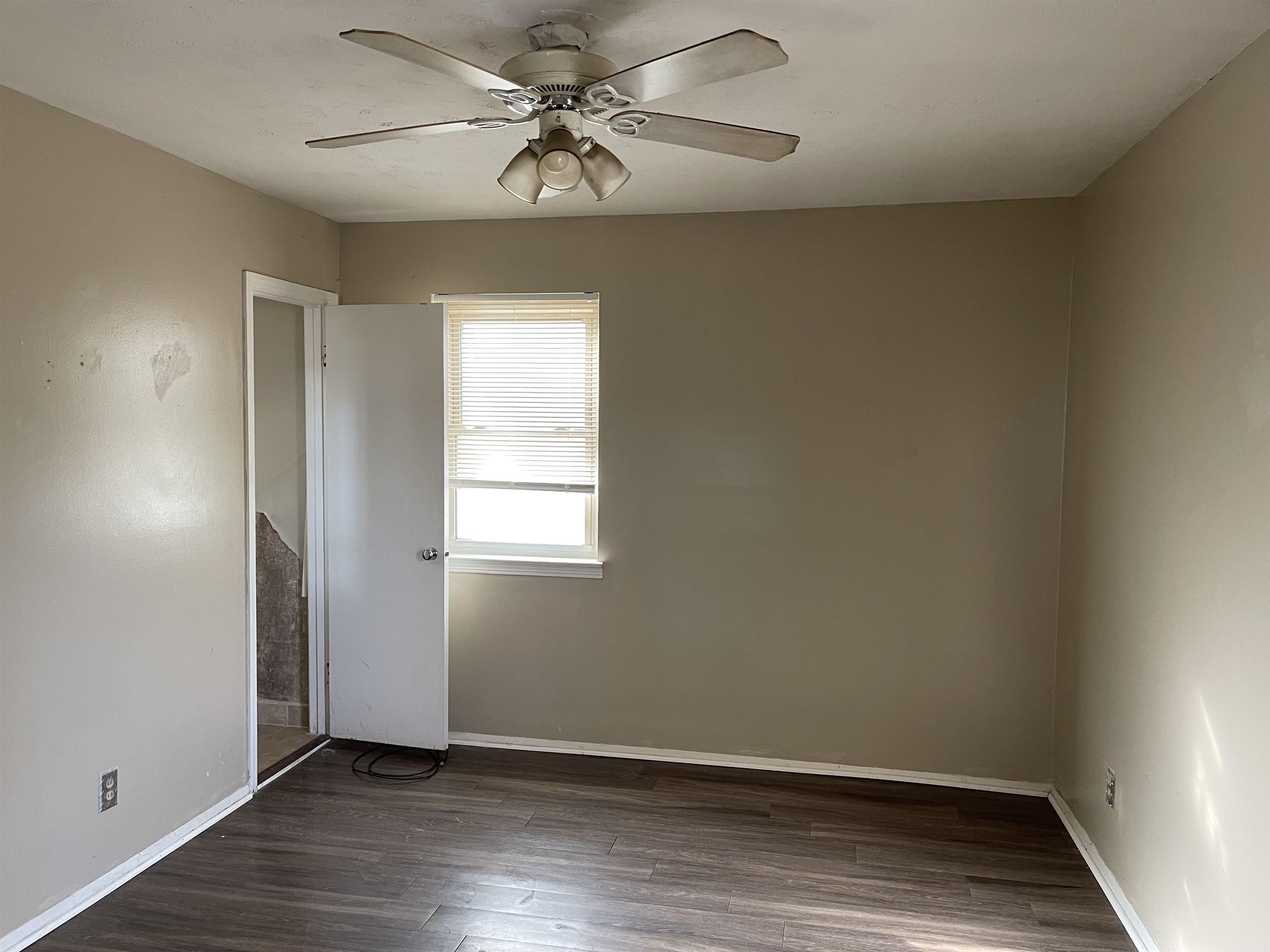 1624 Winfield Road Memphis, TN 38116 - Photo 13 of 14 an empty room with wooden floor fan and windows