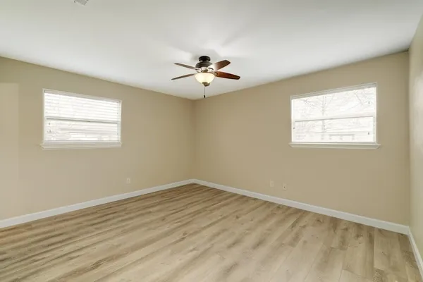 a view of a room with wooden floor and a ceiling fan