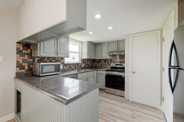 a kitchen with granite countertop stainless steel appliances and wooden cabinets