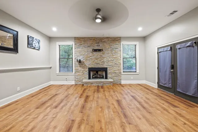 a view of empty room with wooden floor and windows