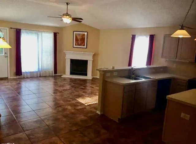a kitchen with granite countertop a stove a sink and a microwave