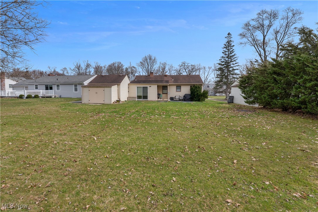 2702 Brunswick Road Youngstown, OH 44511 - Photo 17 of 18 Back of house with a storage shed, an outdoor structure, and a lawn