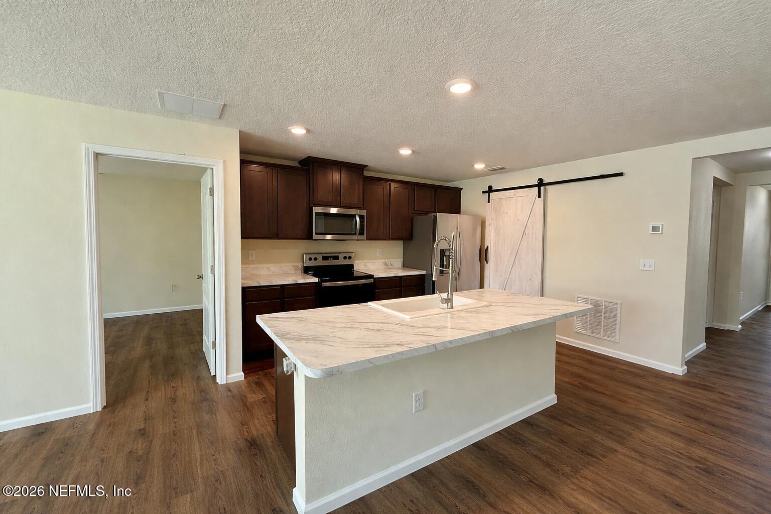 234 Cody Street St. Augustine, FL 32084 - Photo 6 of 20 a kitchen with kitchen island white cabinets and stainless steel appliances