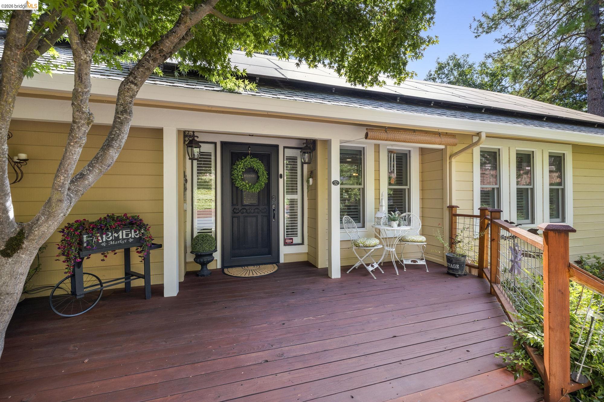 Property entrance featuring roof mounted solar panels and a deck