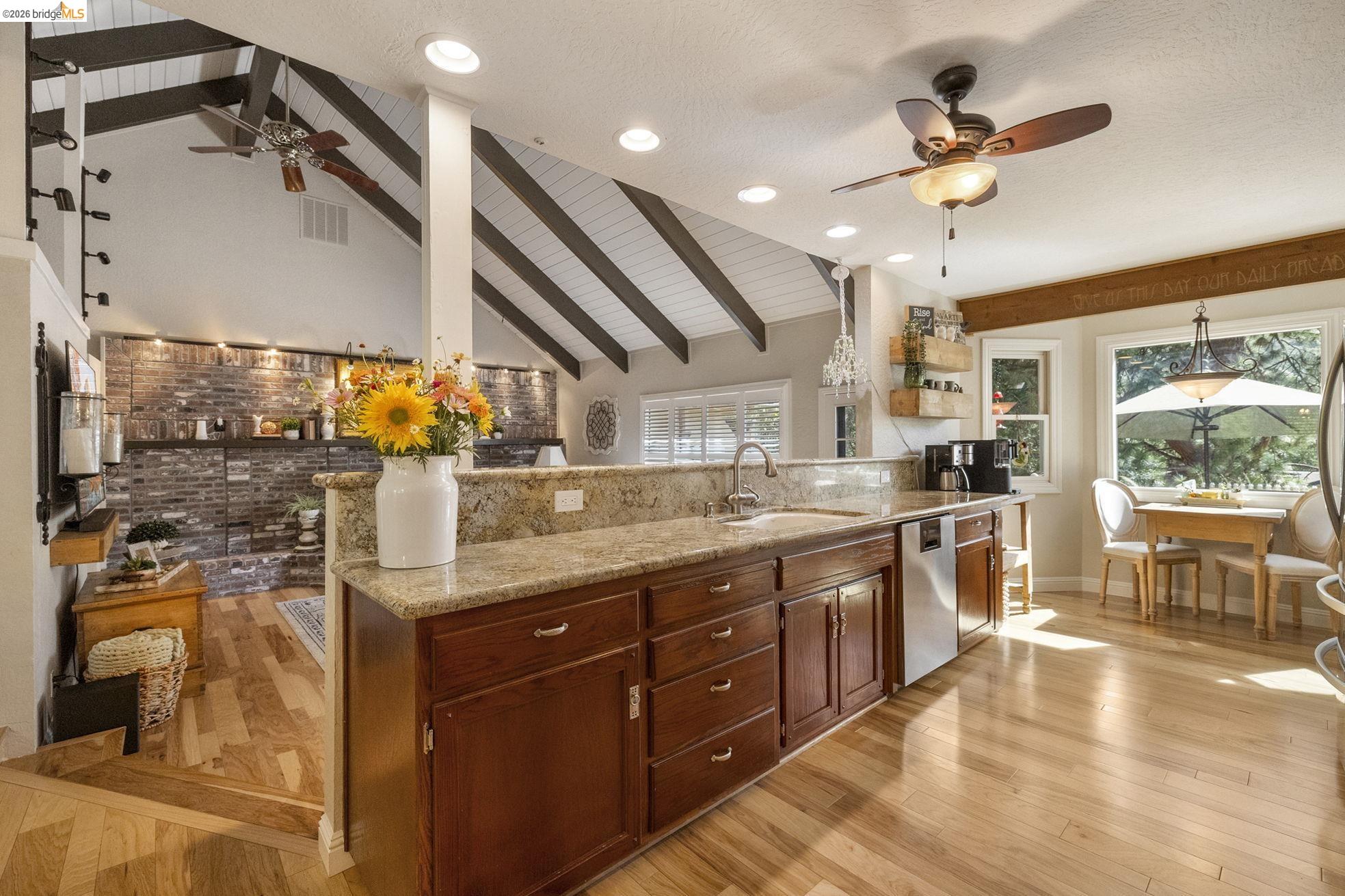 20581 Gerber Road Tuolumne, CA 95379 - Photo 60 of 60 Kitchen featuring beamed ceiling, a ceiling fan, light stone countertops, open floor plan, and light wood-style flooring