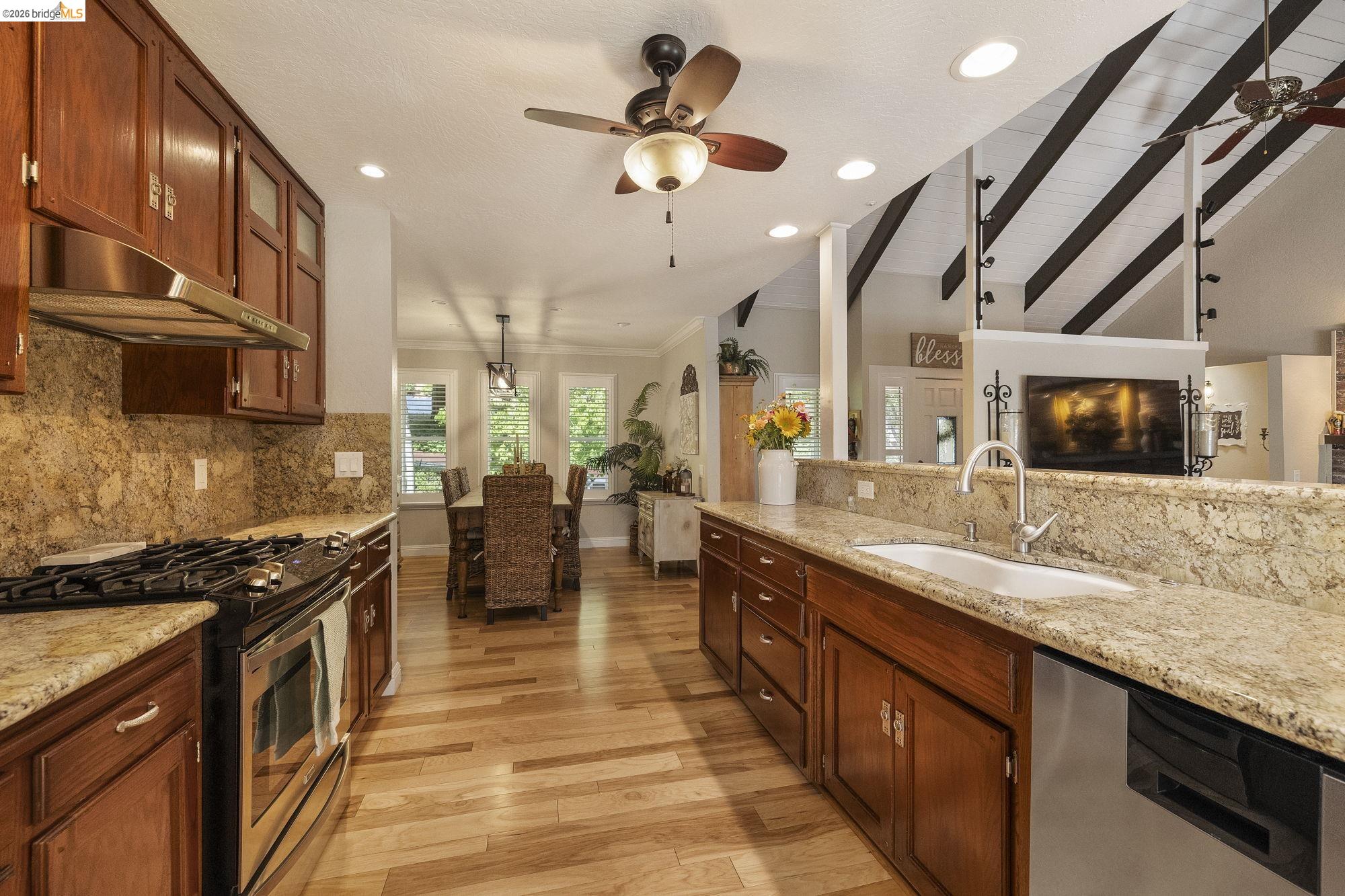 20581 Gerber Road Tuolumne, CA 95379 - Photo 12 of 60 Kitchen with appliances with stainless steel finishes, decorative backsplash, a ceiling fan, light stone counters, and recessed lighting