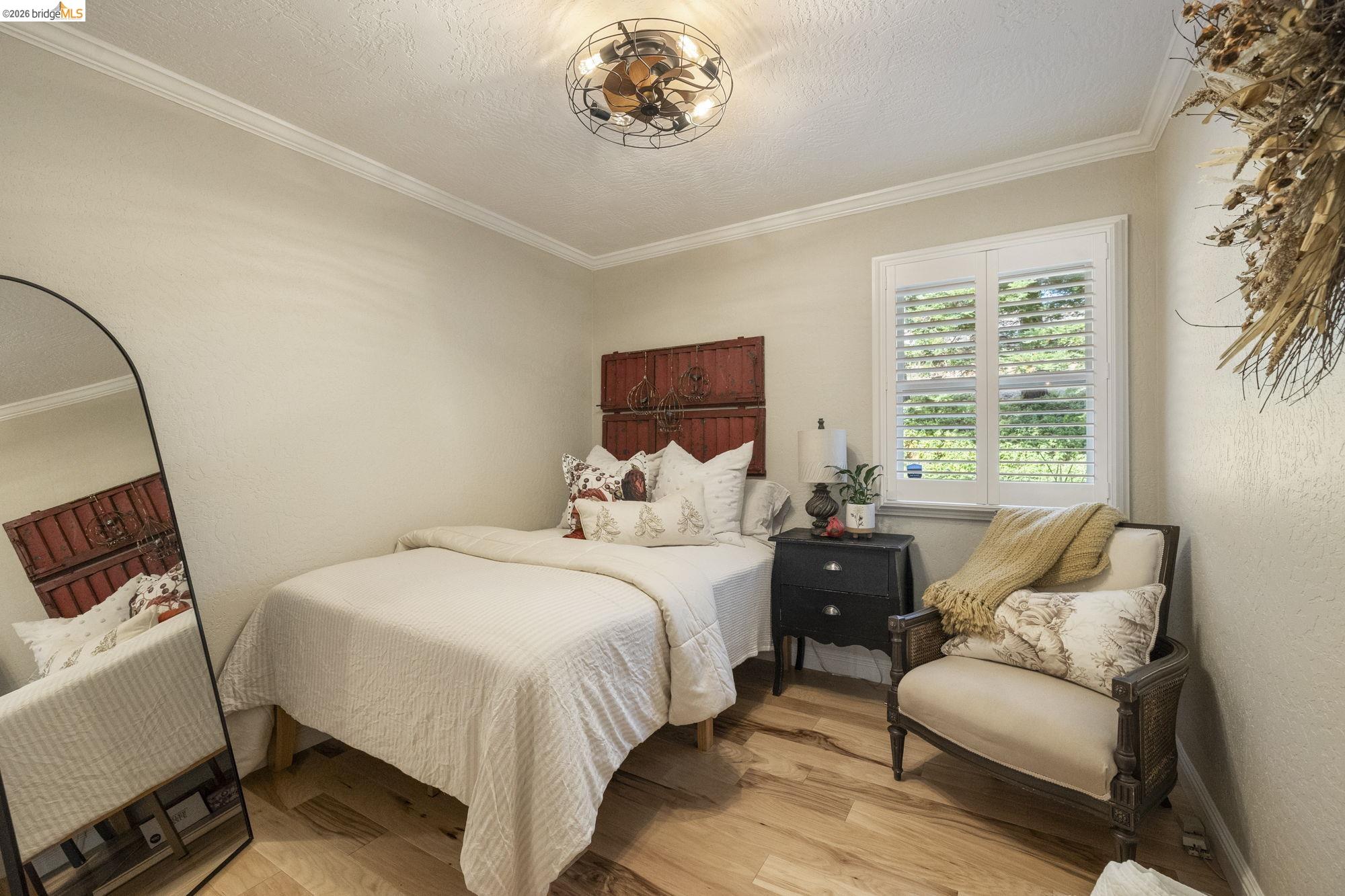 20581 Gerber Road Tuolumne, CA 95379 - Photo 21 of 60 Bedroom featuring crown molding, a textured ceiling, light wood finished floors, and a textured wall