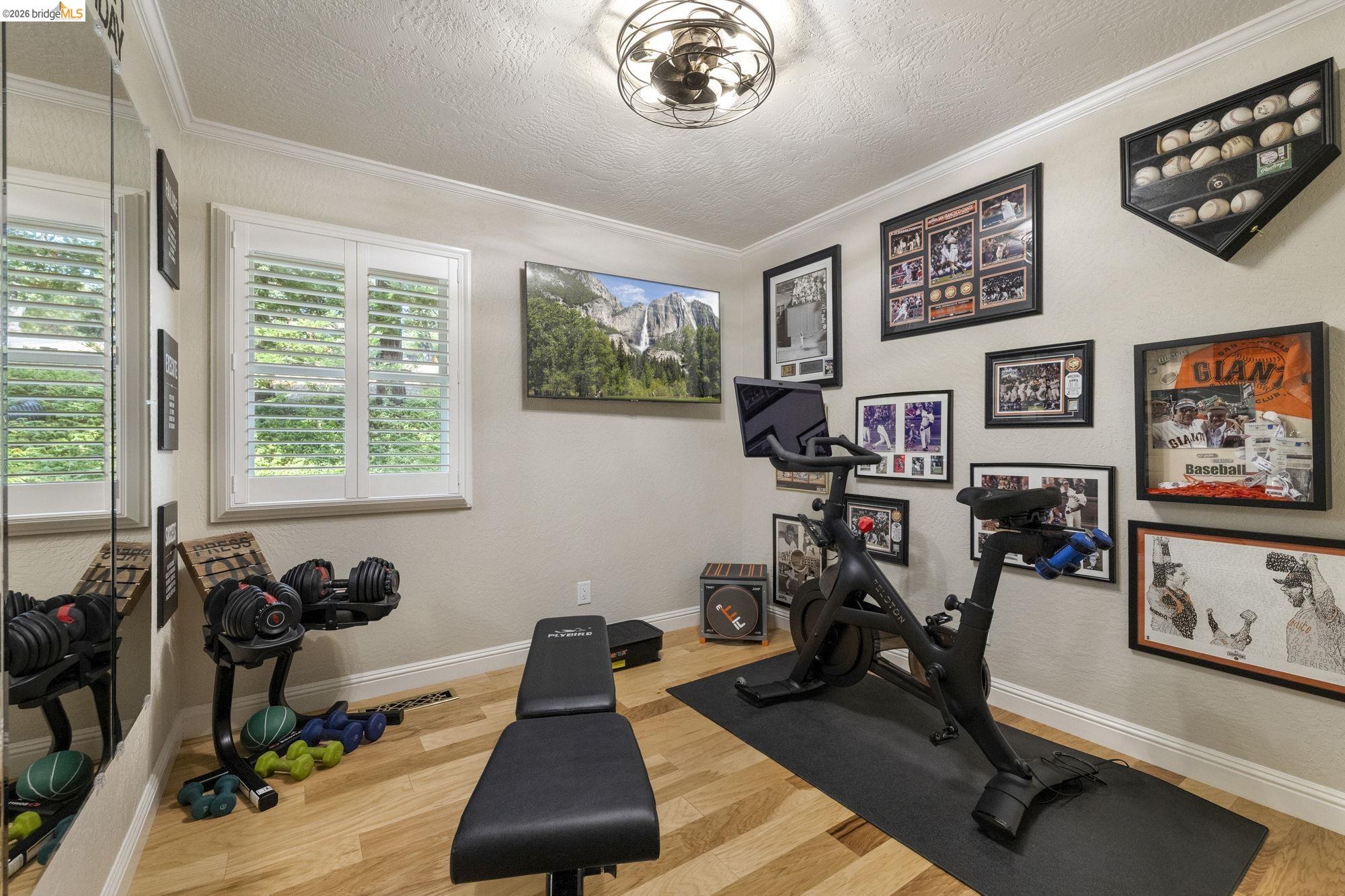 20581 Gerber Road Tuolumne, CA 95379 - Photo 22 of 60 Workout room featuring light wood finished floors, a textured ceiling, and crown molding